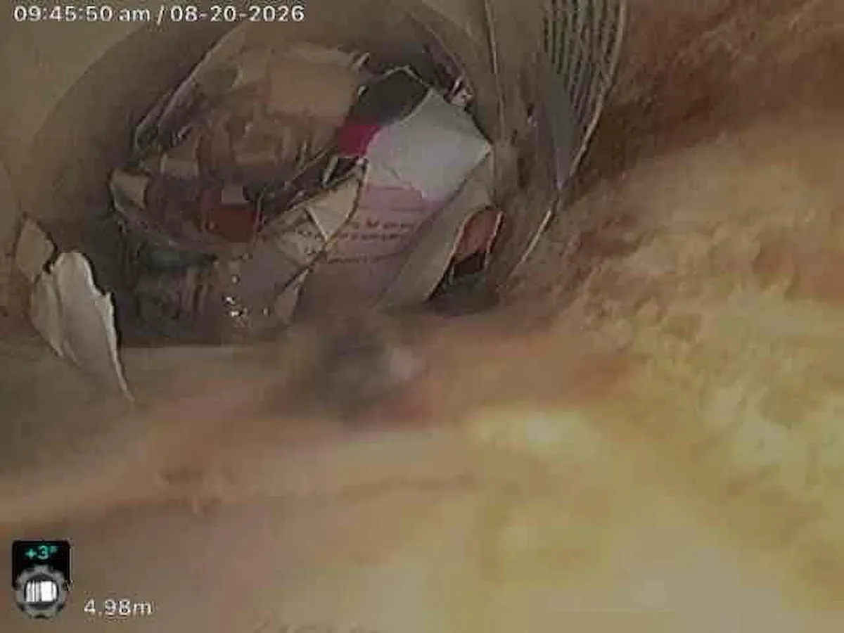 Camera view of paper and plastic bags blocking a drain in Alfredton