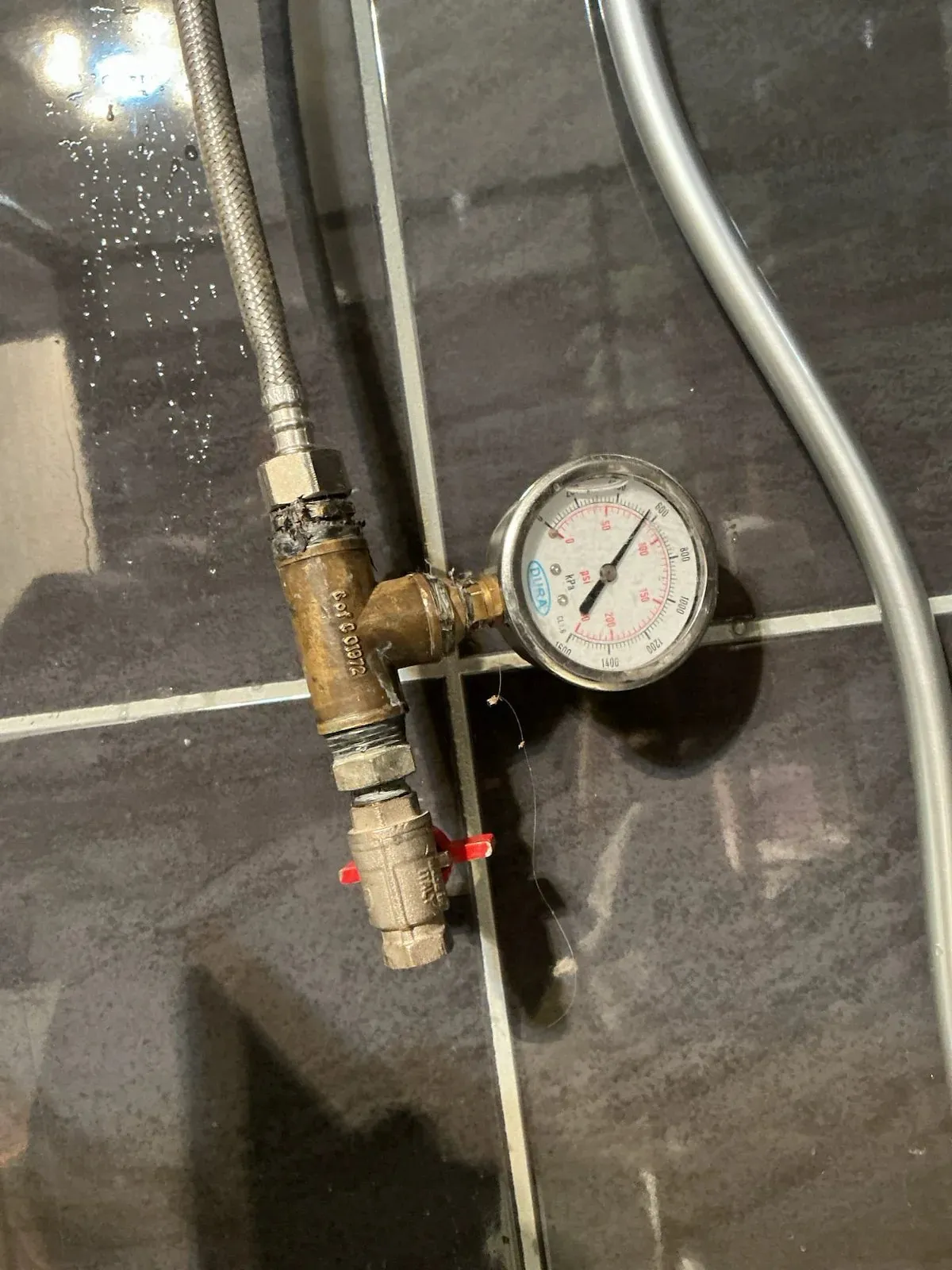 Pressure gauge connected to the shower line for testing