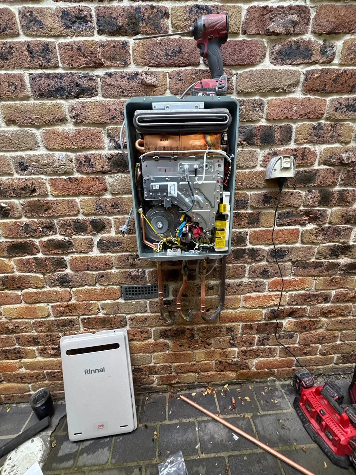Old continuous flow unit opened up, with the new Rinnai unit ready to go in