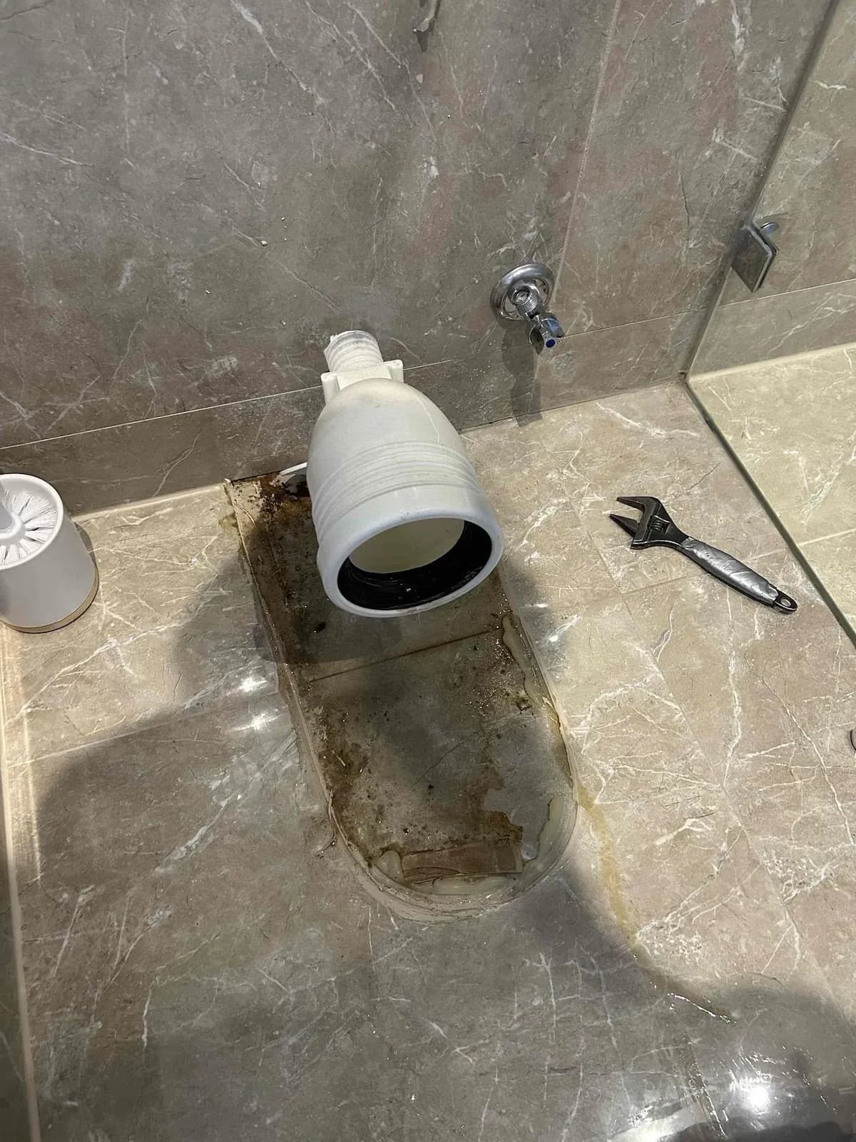 Toilet removed showing the leaking pan connection