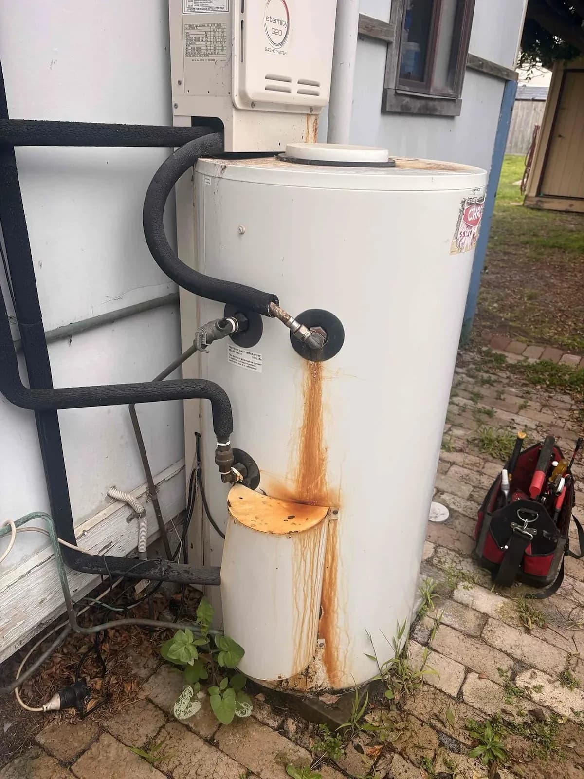 Old hot water unit rusting and leaking