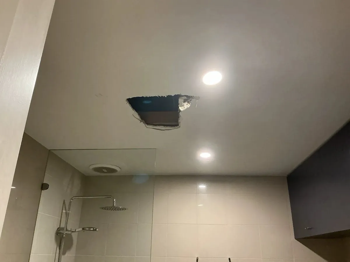 Ceiling opened below the bathroom to trace the leak