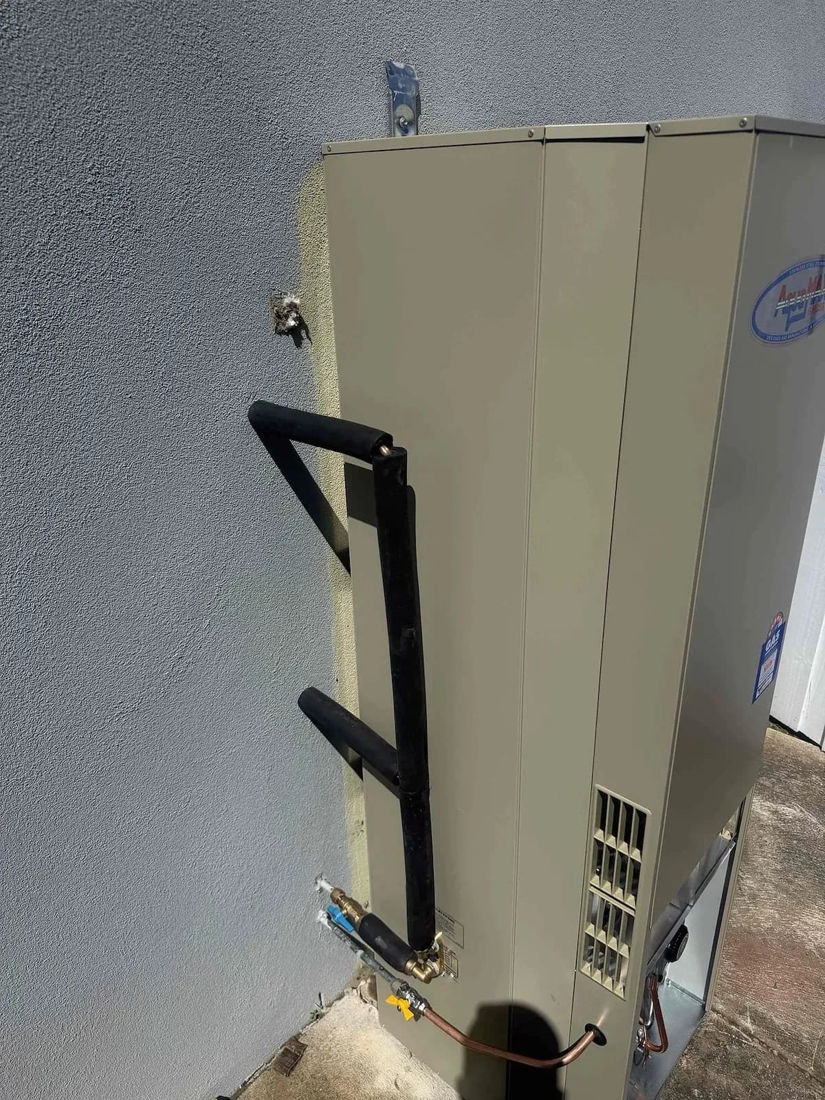 New gas hot water unit installed against the house