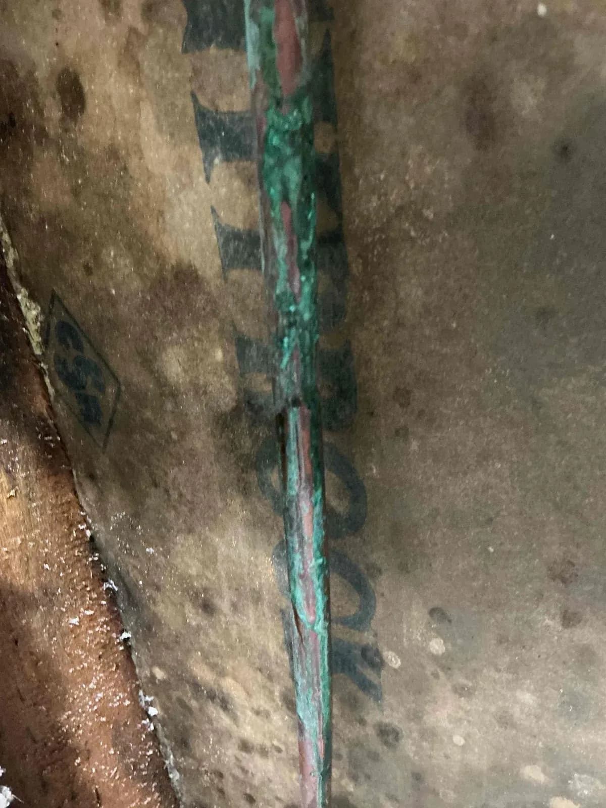 Burst copper pipe exposed inside the wardrobe wall