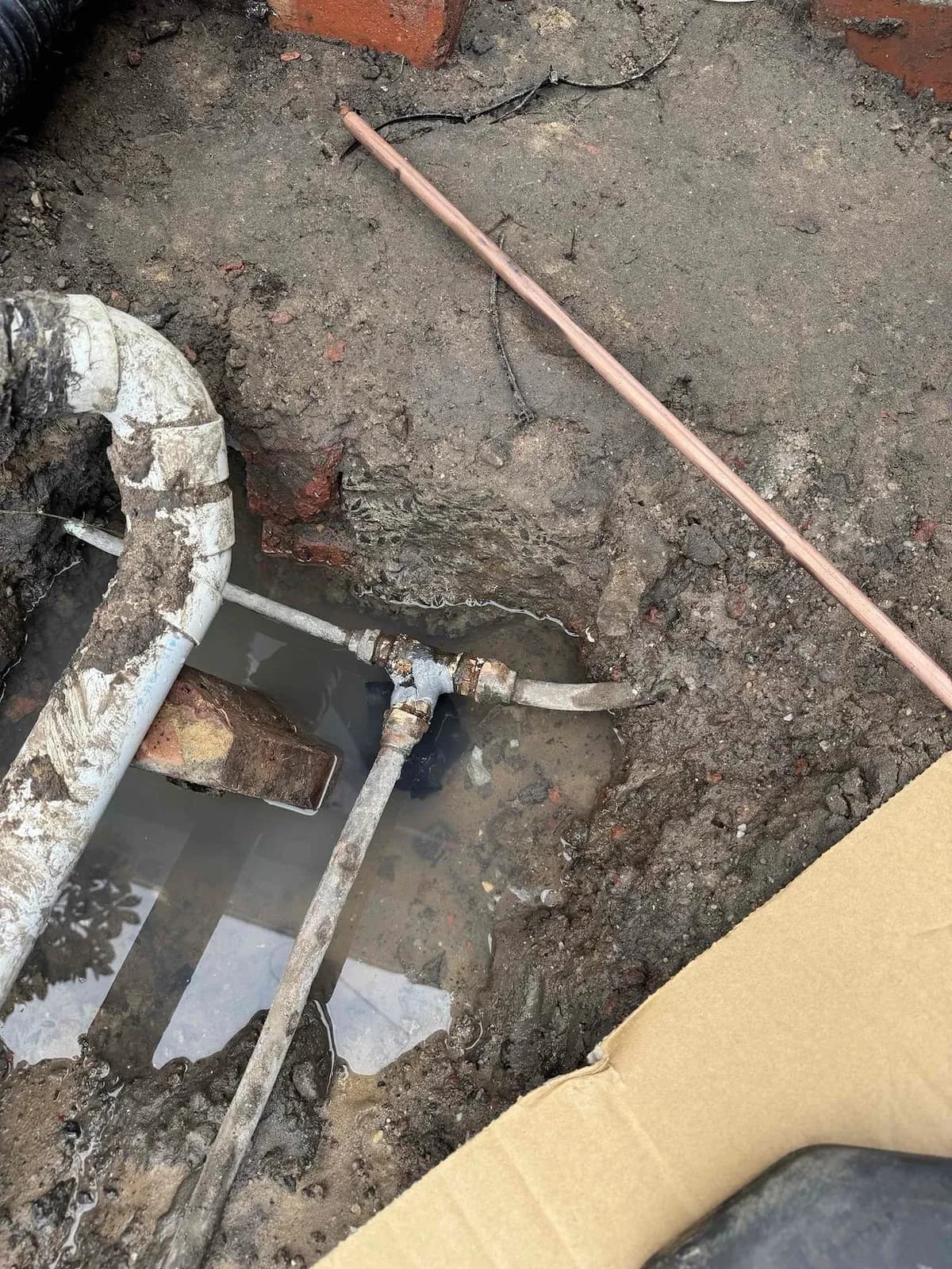 New copper pipe section laid in the trench