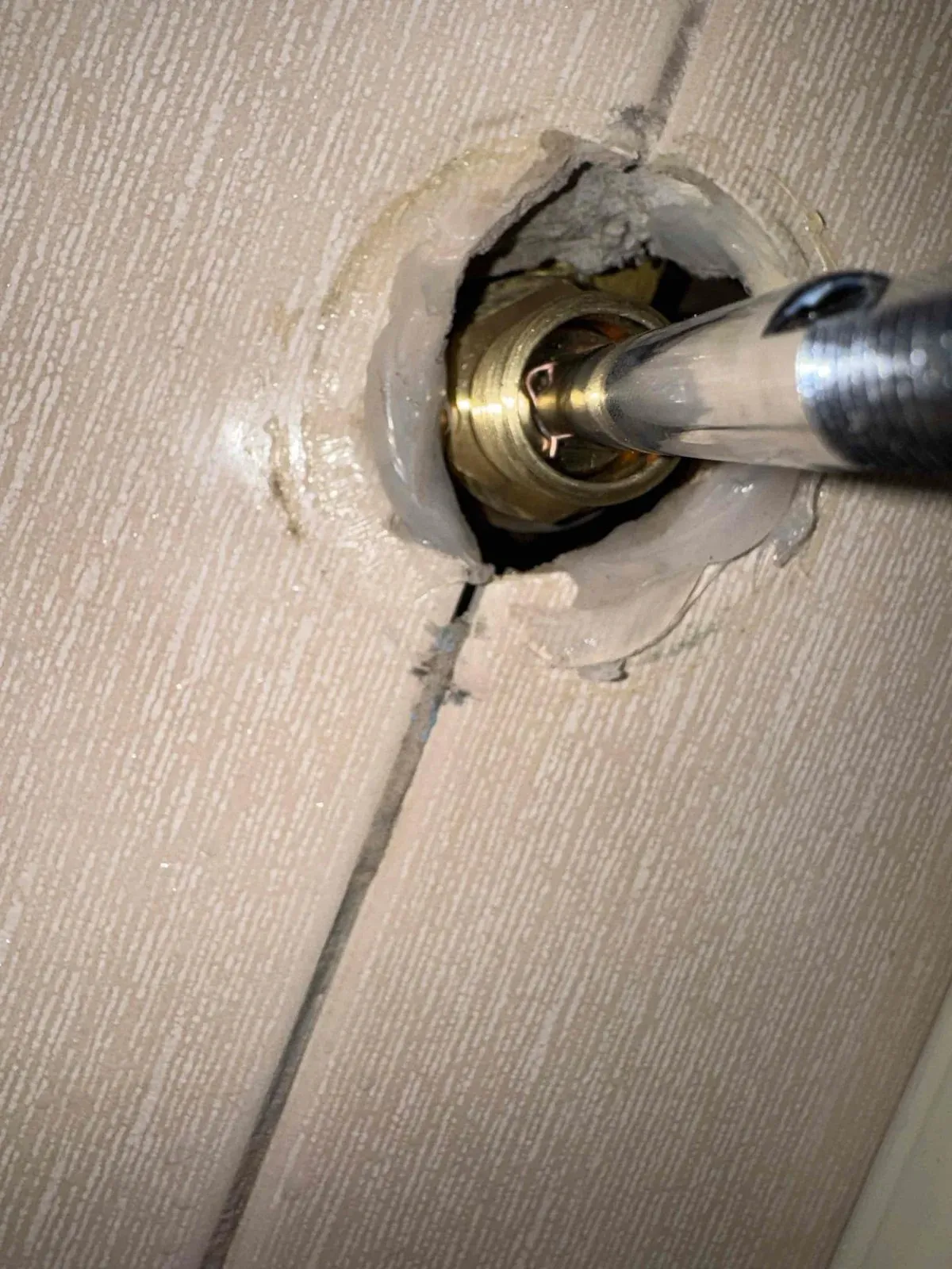 Old shower tap body exposed in the wall