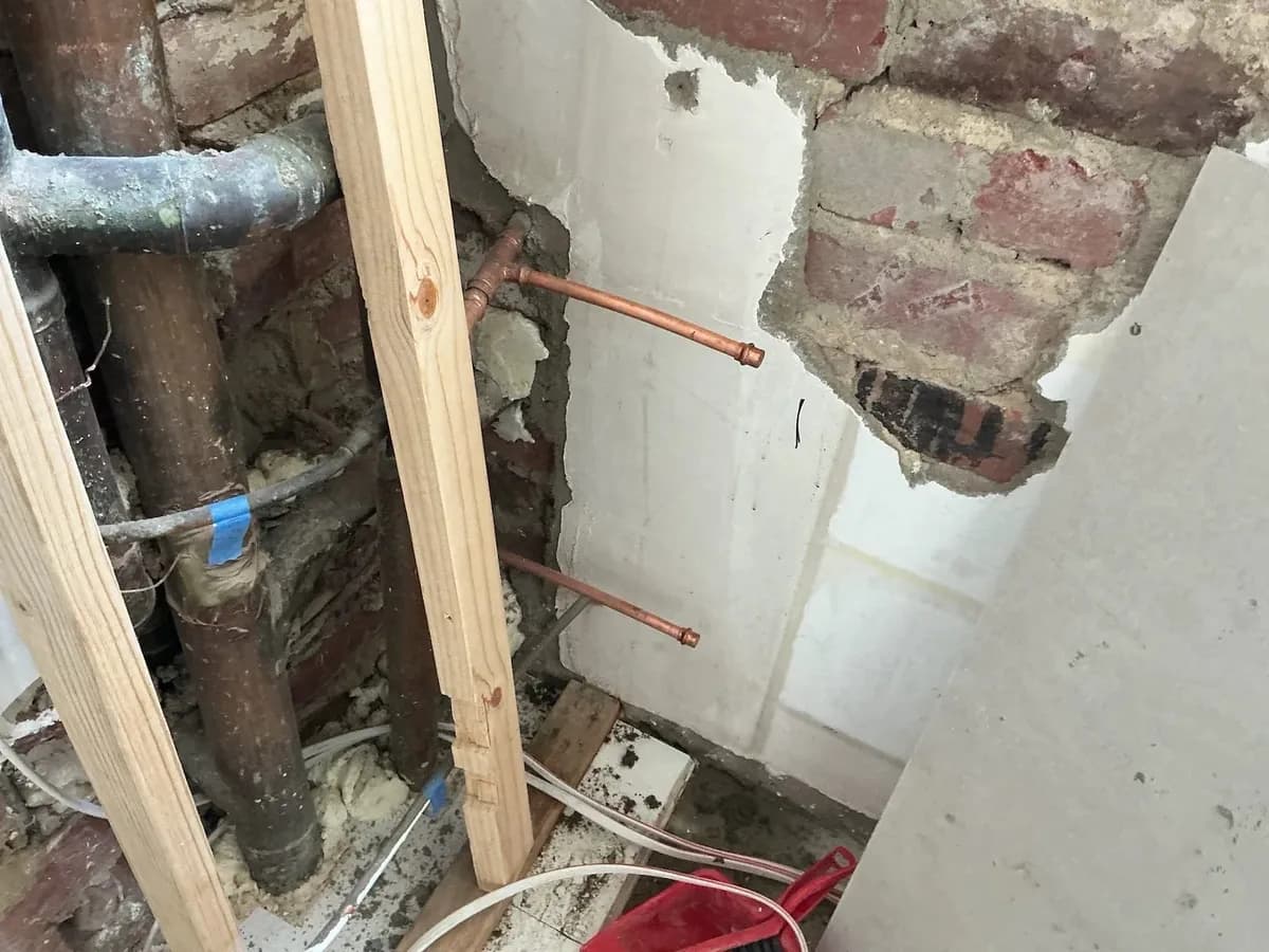 Wall opened to reach the leaking copper pipes