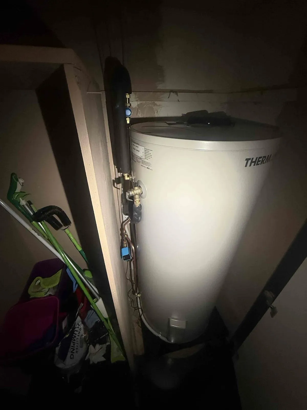 Old electric hot water unit in the laundry cupboard