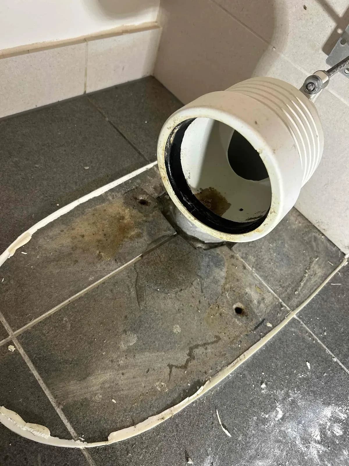 Toilet pan removed showing the leak stain on the floor