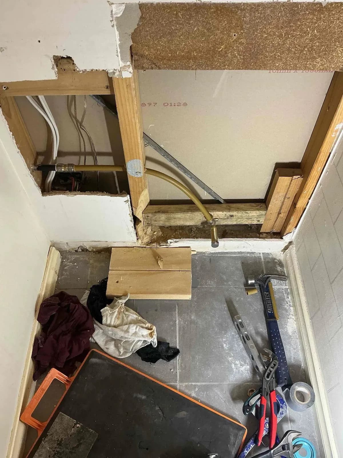 Wall opened up to alter the water pipes