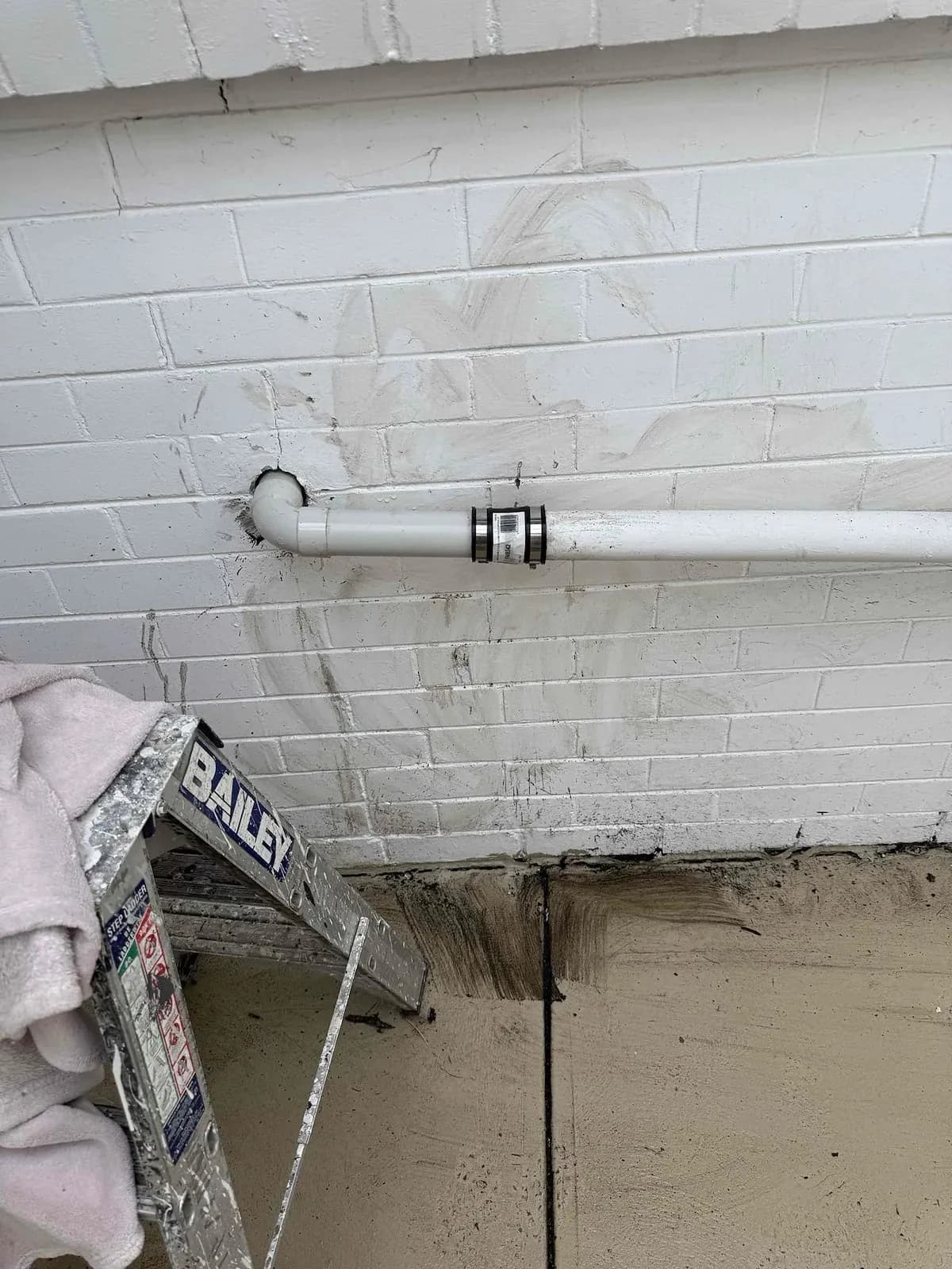 Repaired waste pipe outside the kitchen wall