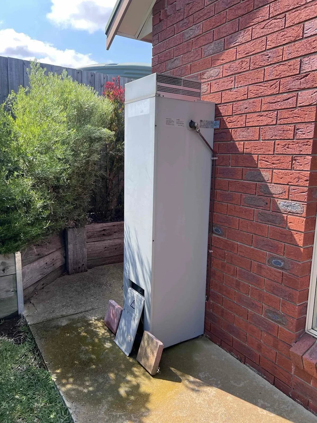 Hot water system beside the house after installation