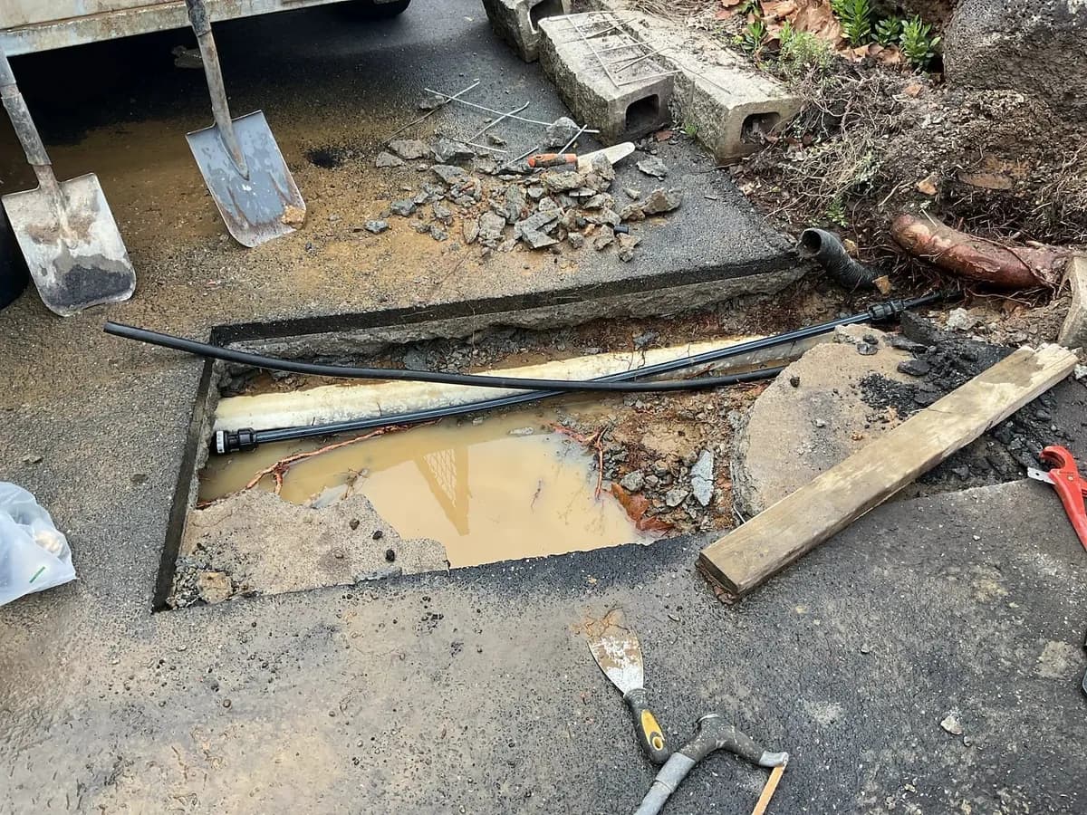 Concrete cut open to reach the burst underground water pipe