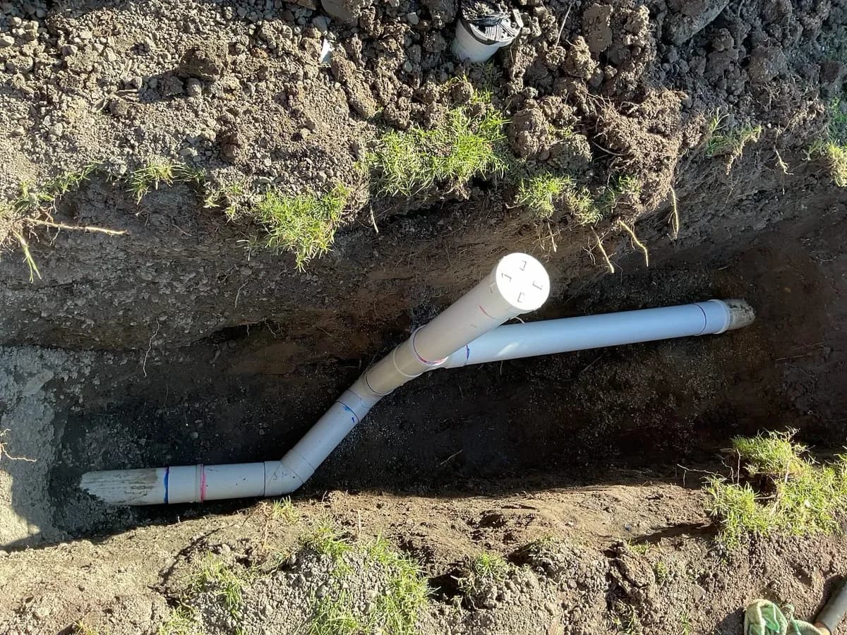 New PVC sewer pipe and riser laid in an open trench