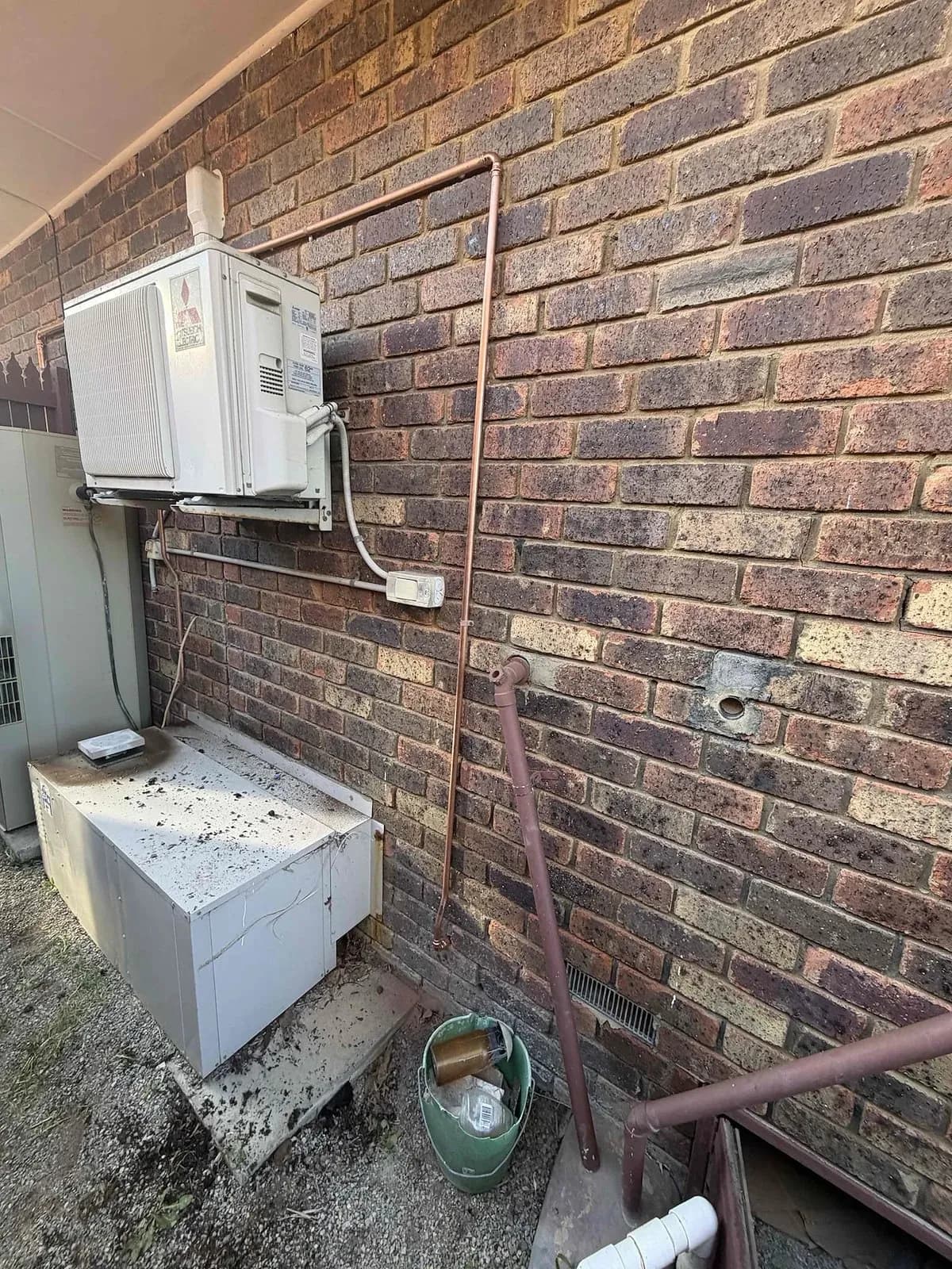 Gas line and appliances along the side of a brick house