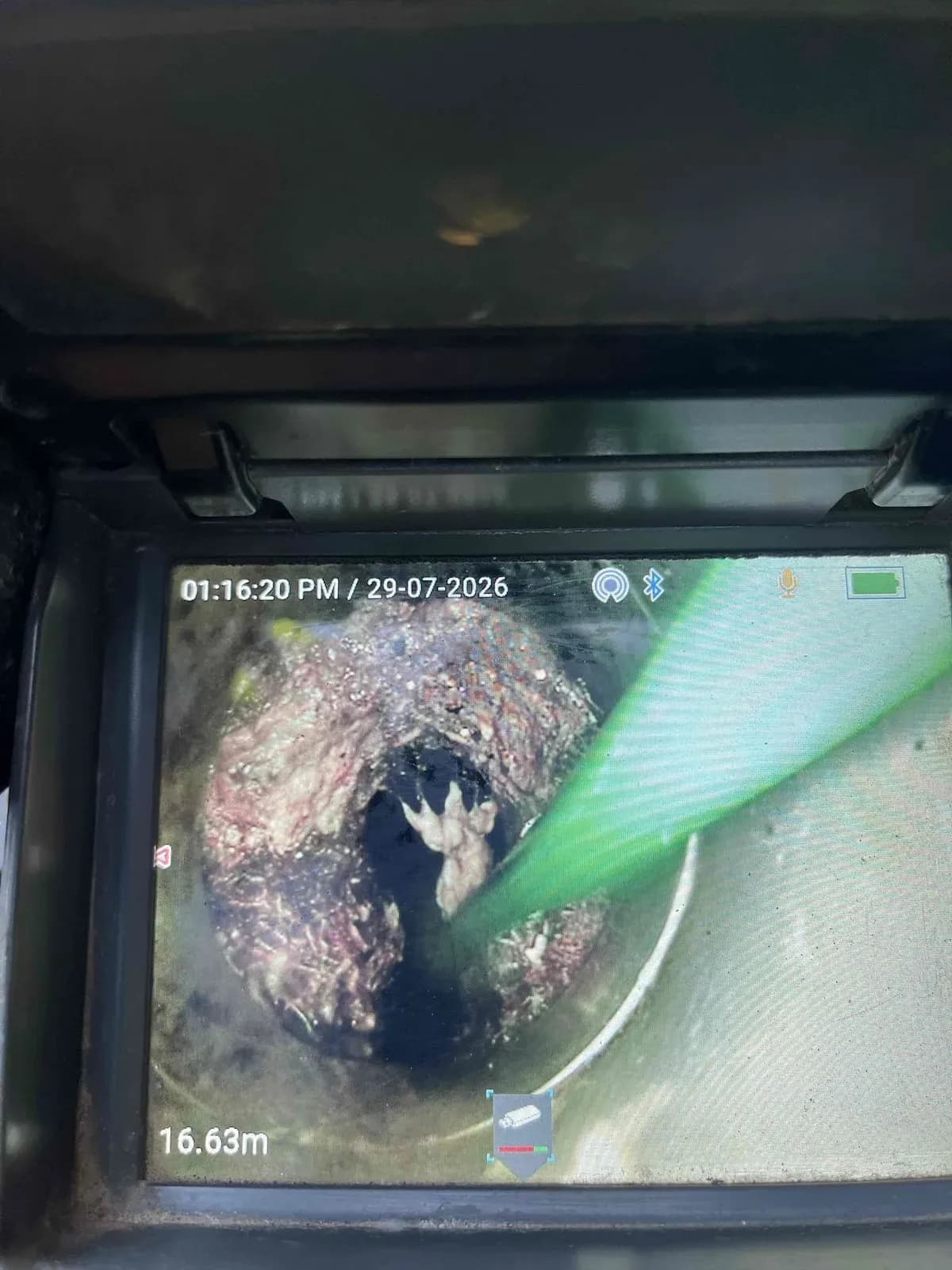 Camera view of tree roots packed inside the sewer pipe