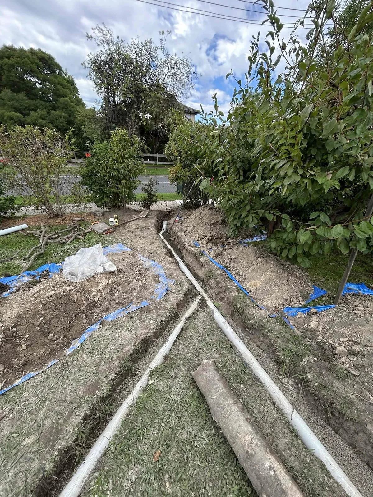 Trench with new stormwater pipe laid along the garden