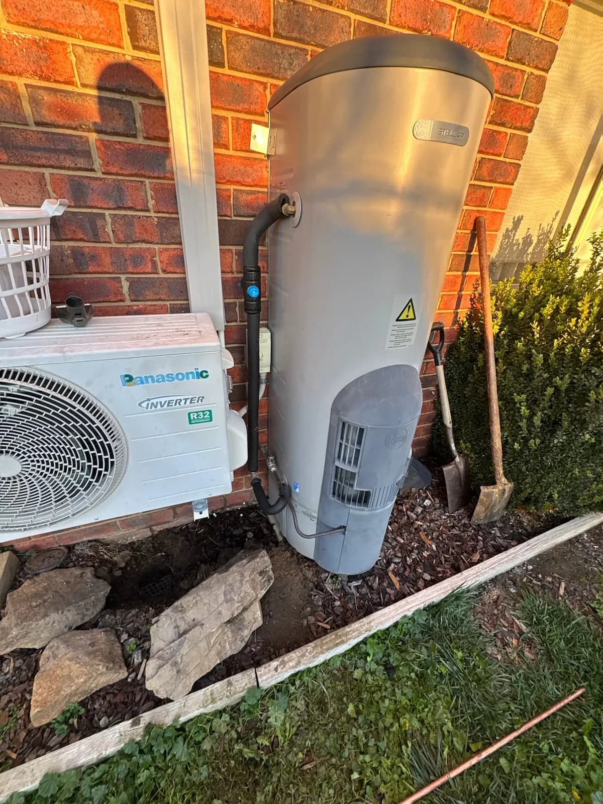 Hot water system beside a brick house