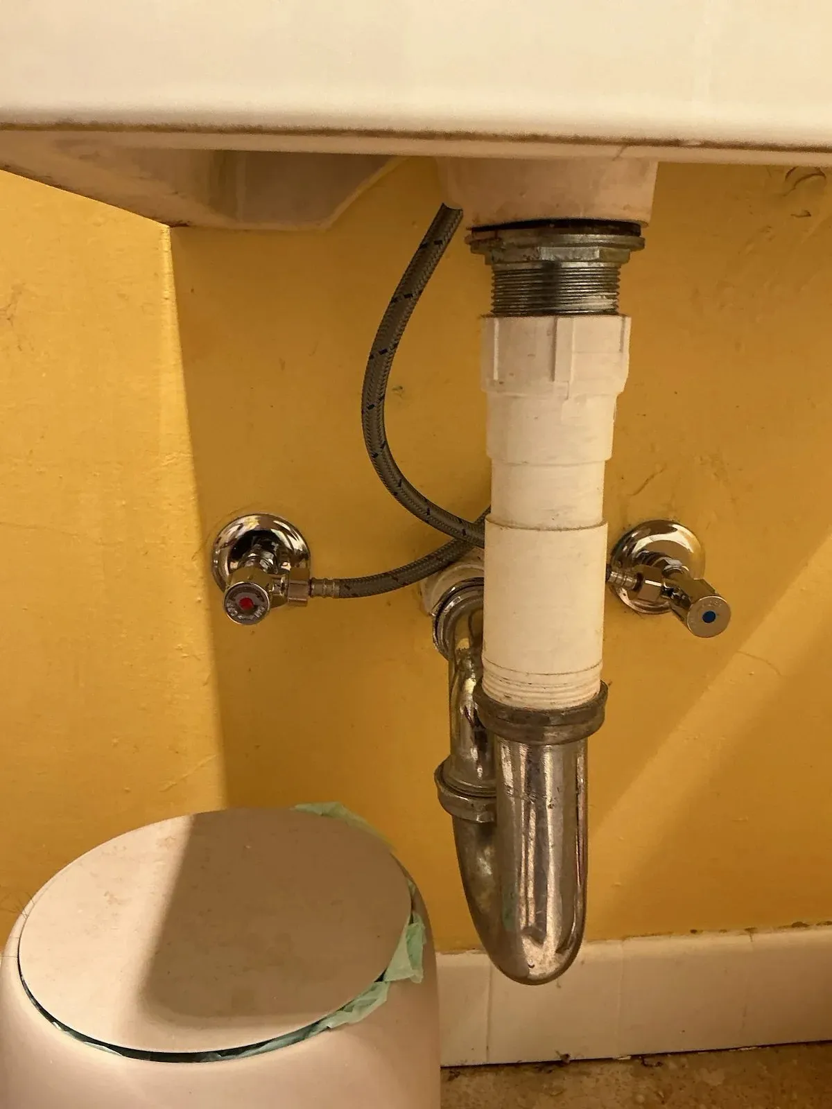 Pipework and isolation valves under a bathroom basin