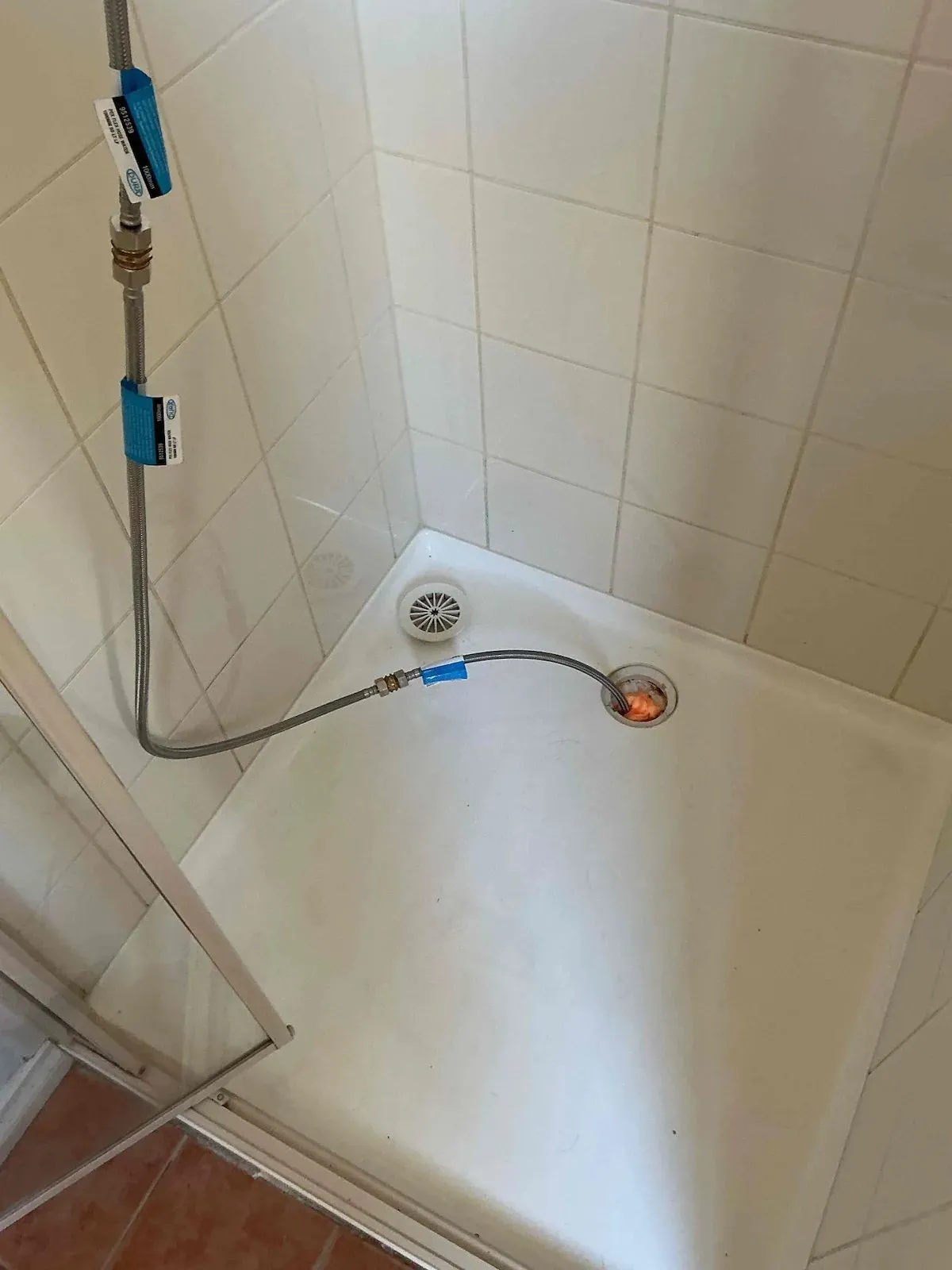 Shower base with the test hose connected for a flood test