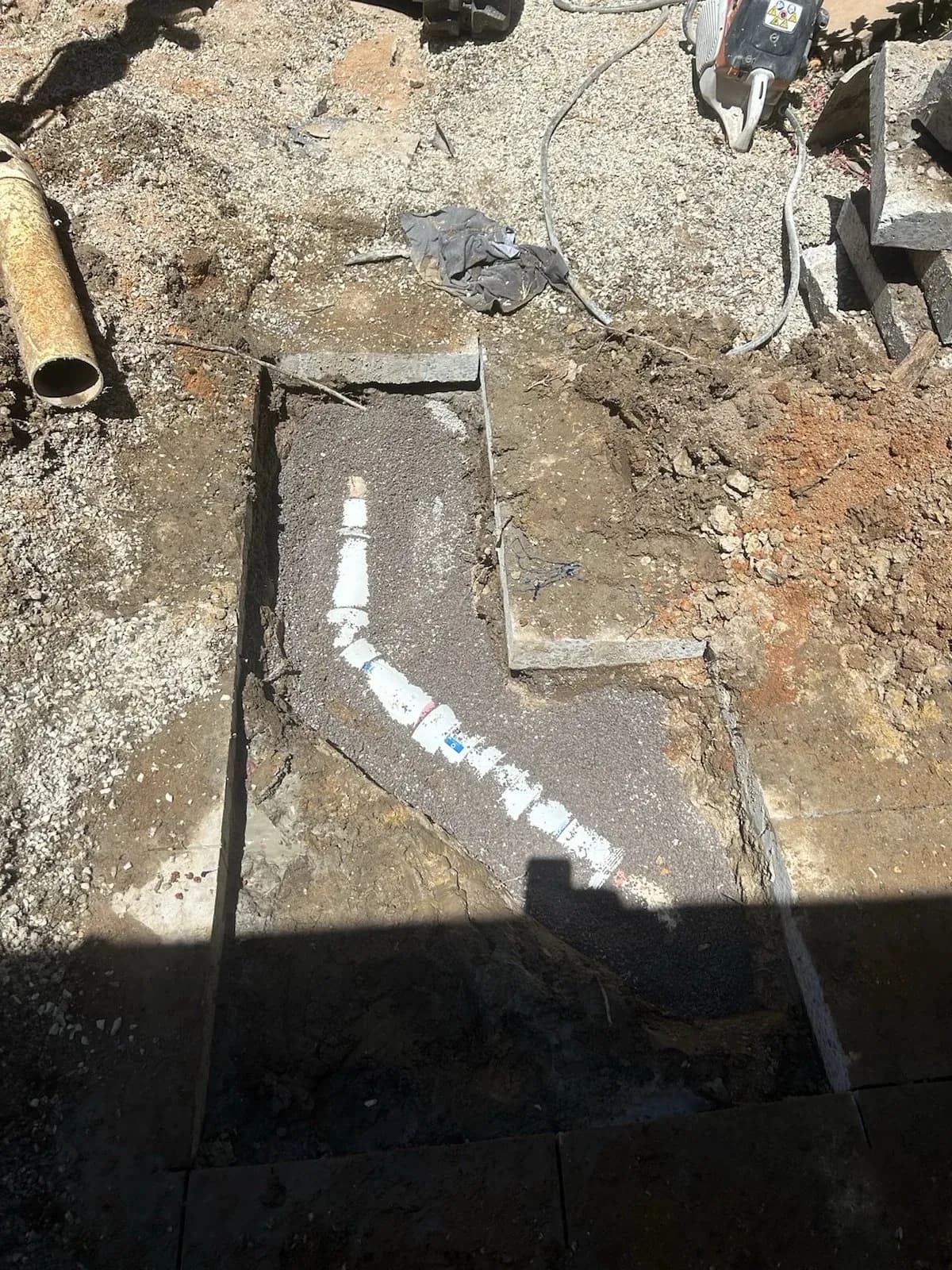 Concrete cut open along the broken sewer pipe