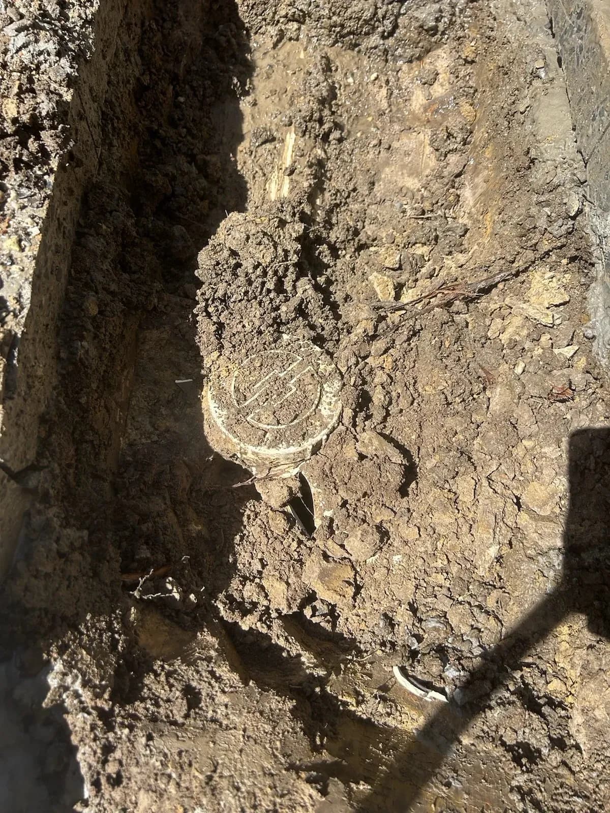 Sewer pipe exposed in the trench
