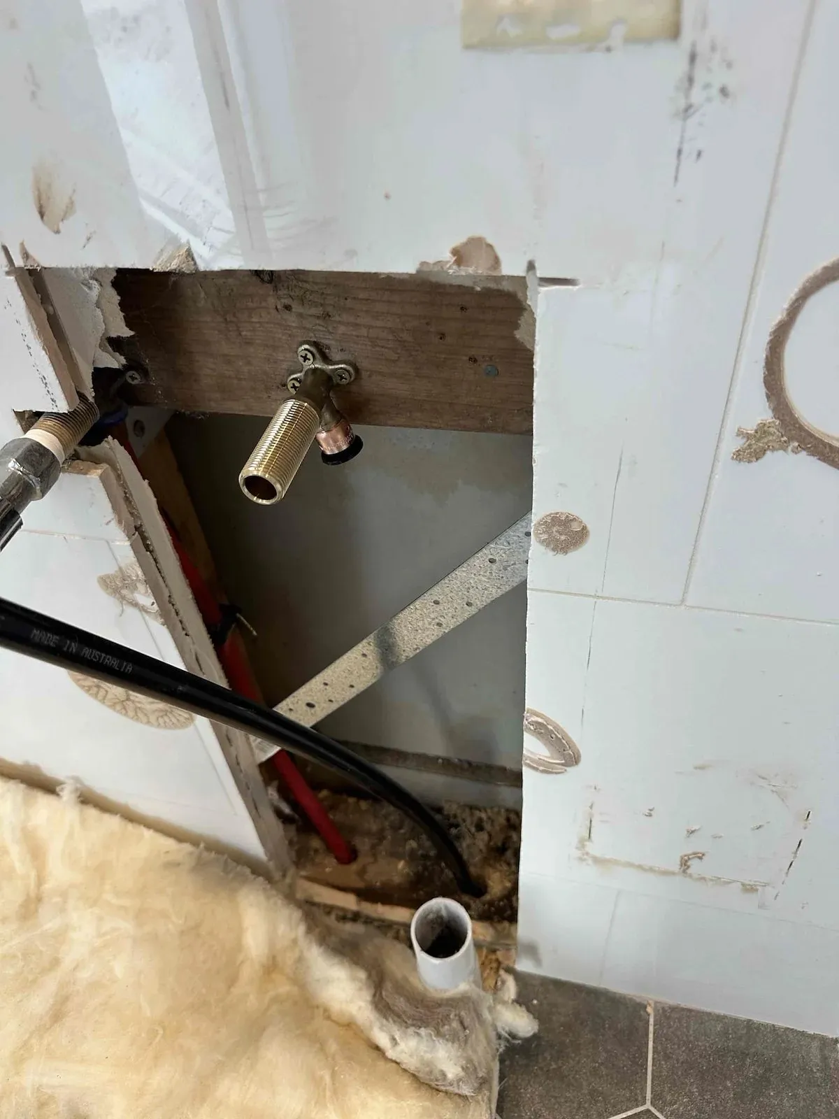 Wall opened up to reach the cold water pipe