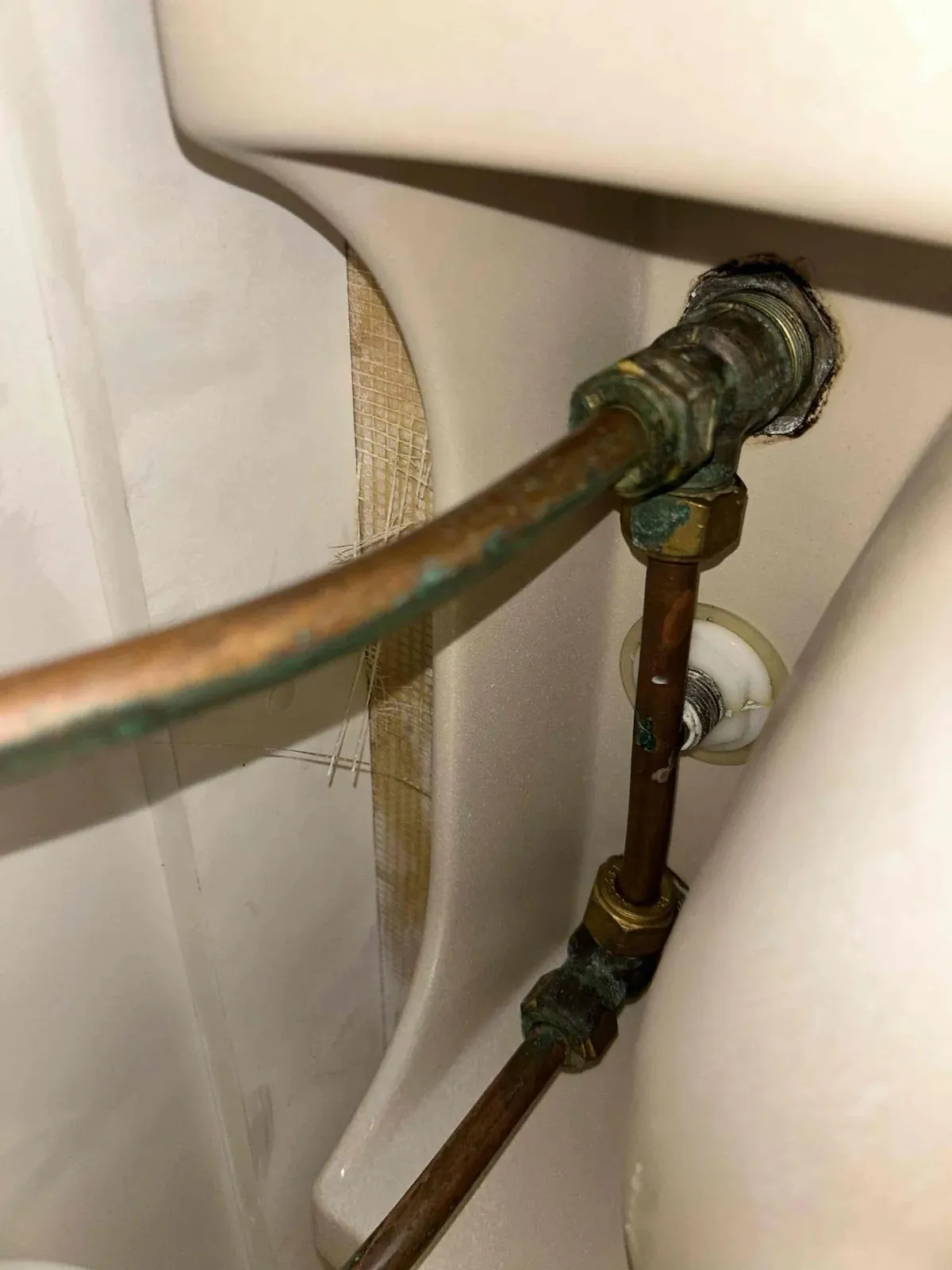 Corroded copper pipe joint behind the toilet