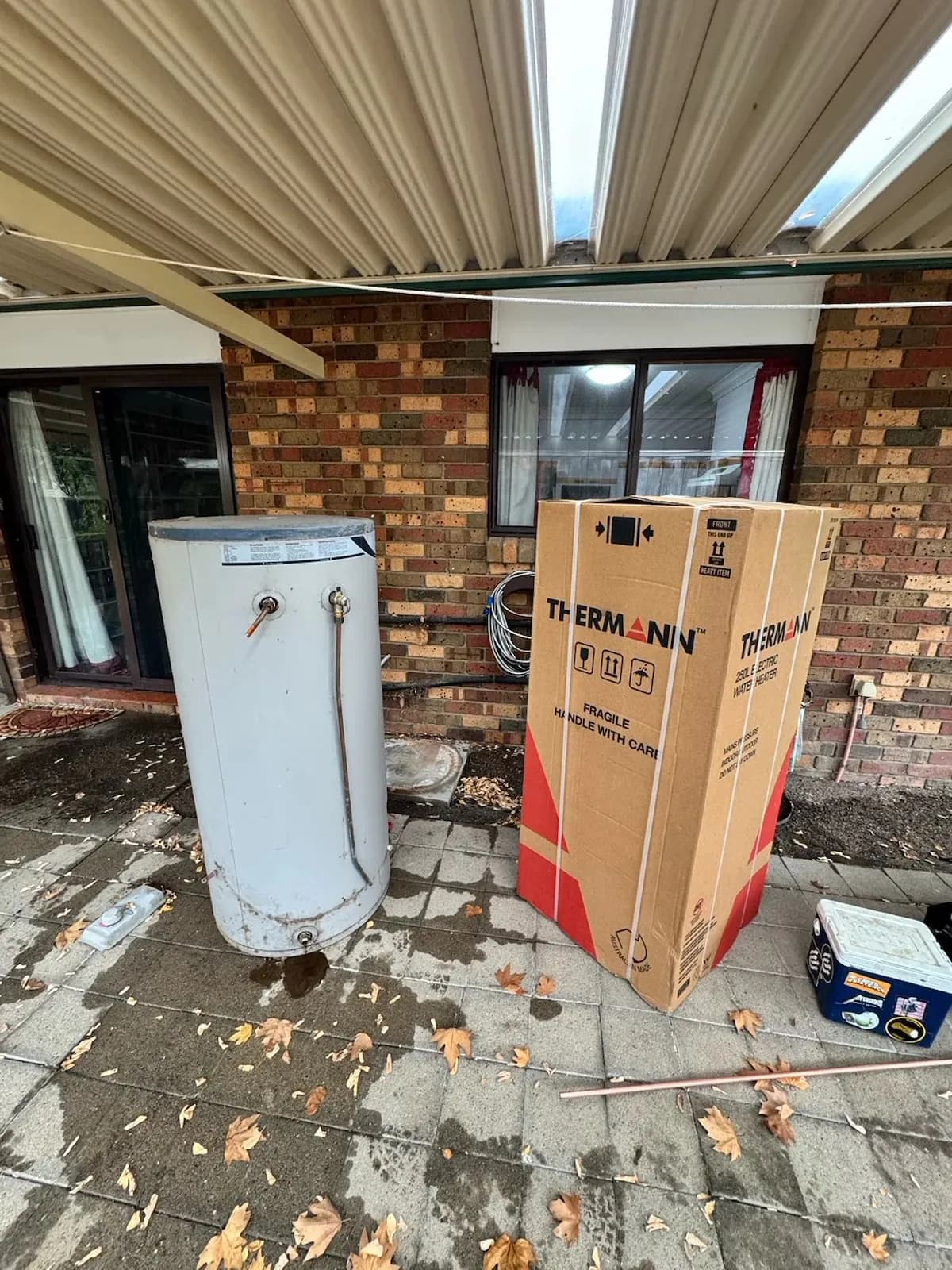 Old electric hot water unit removed, new unit still in its box