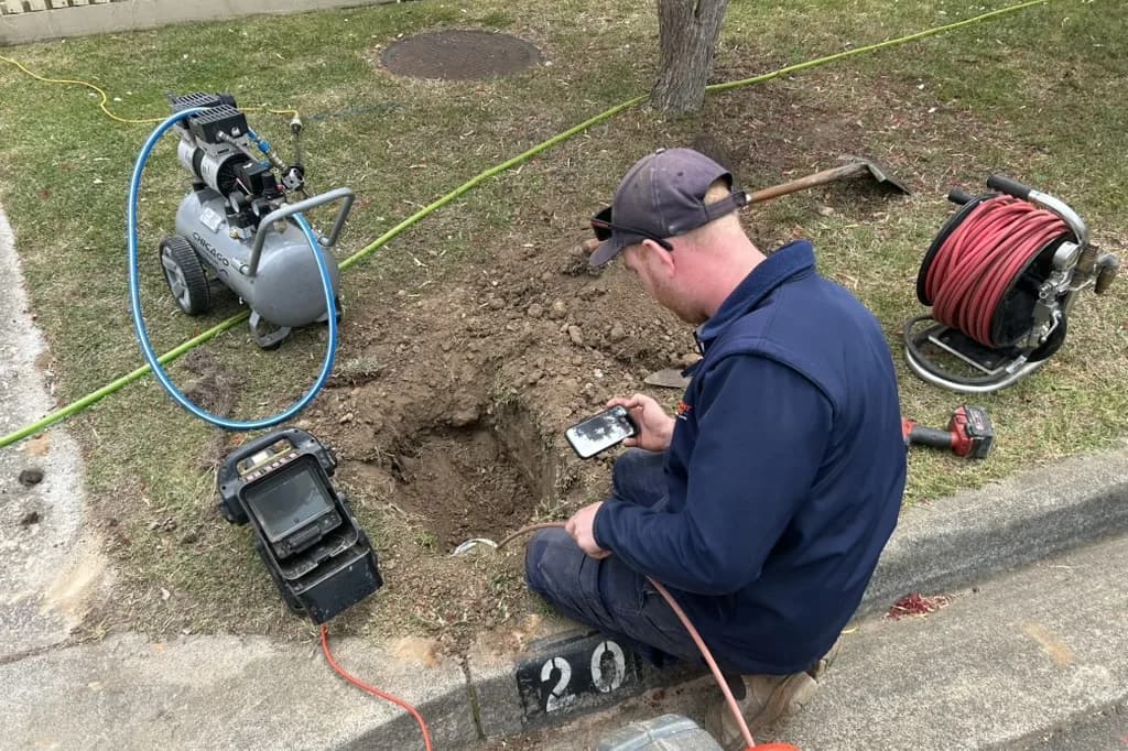 A Fix-It Right plumber locating a blocked drain line from the street access point
