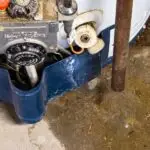 Leaking hot water heater base with visible water pooling on the floor during a plumbing inspection by Fix-It Right Plumbing