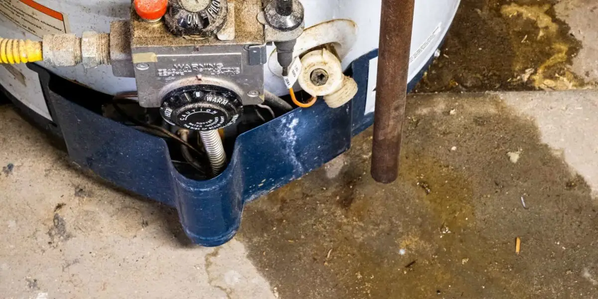 Leaking hot water heater base with visible water pooling on the floor during a plumbing inspection by Fix-It Right Plumbing